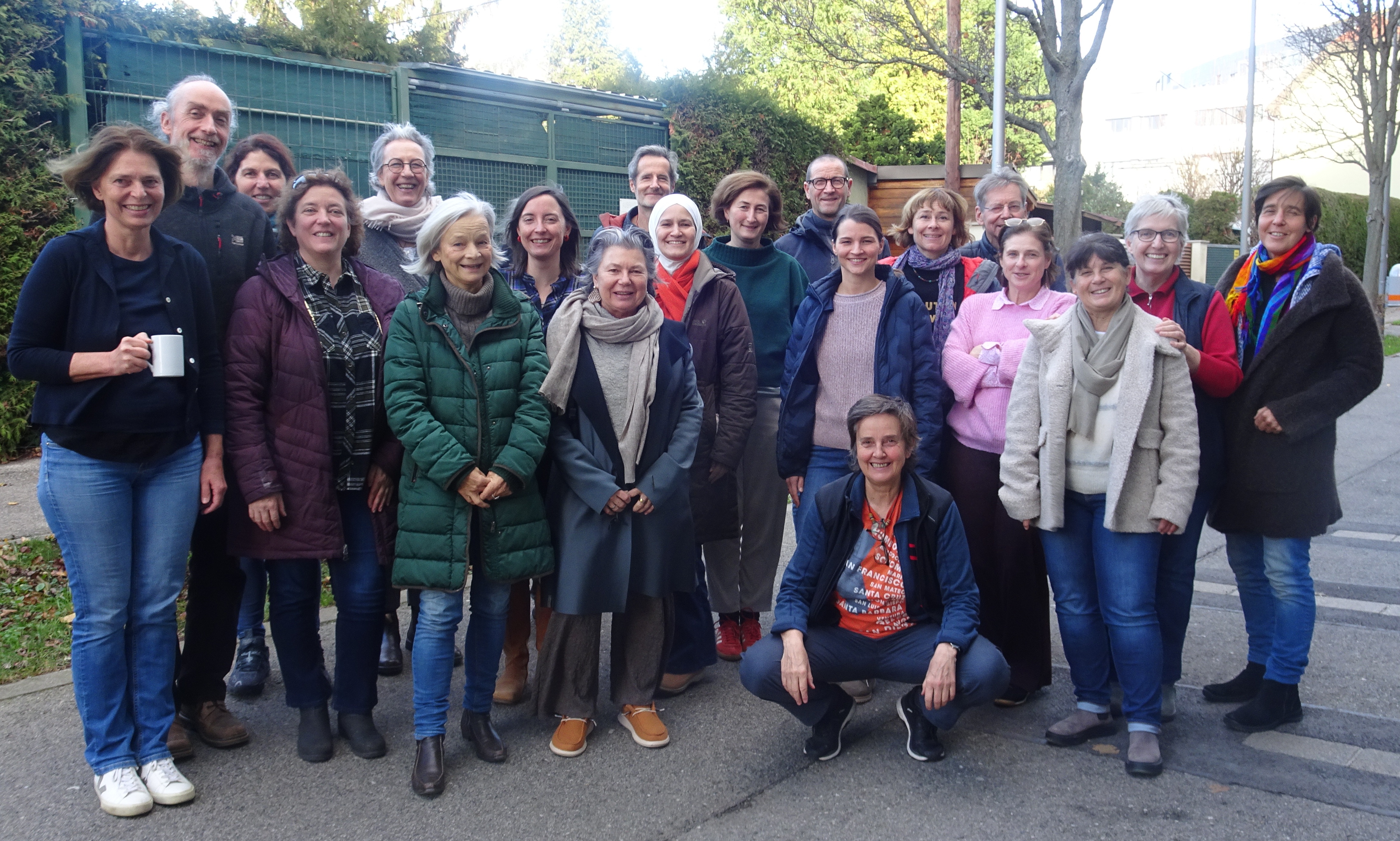 Auf dem Foto stehen die Teilnehmenden mit der Referentin in einem Außenbereich zusammen und lächeln.